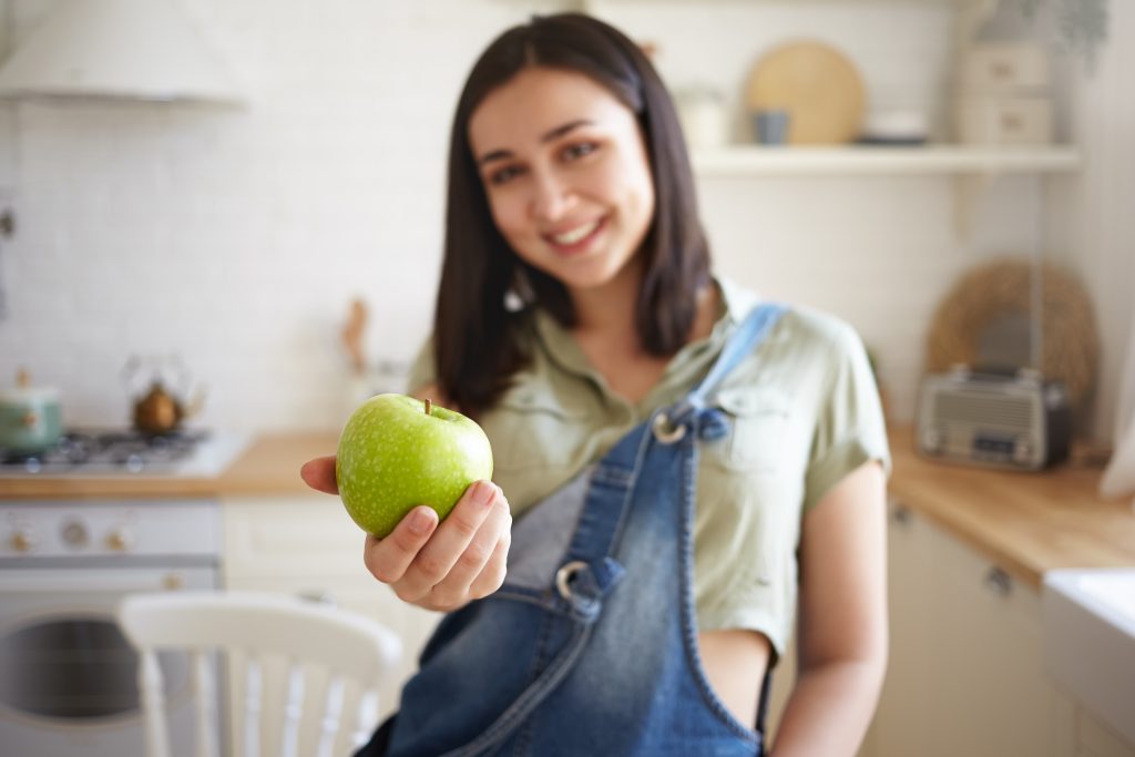 Mujer dueña de negocio sonriendo con energía alimentándose sanamente
