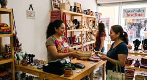Mujer emprendedora mexicana atendiendo su negocio con apoyo de un crédito inicial y monto mínimo.
